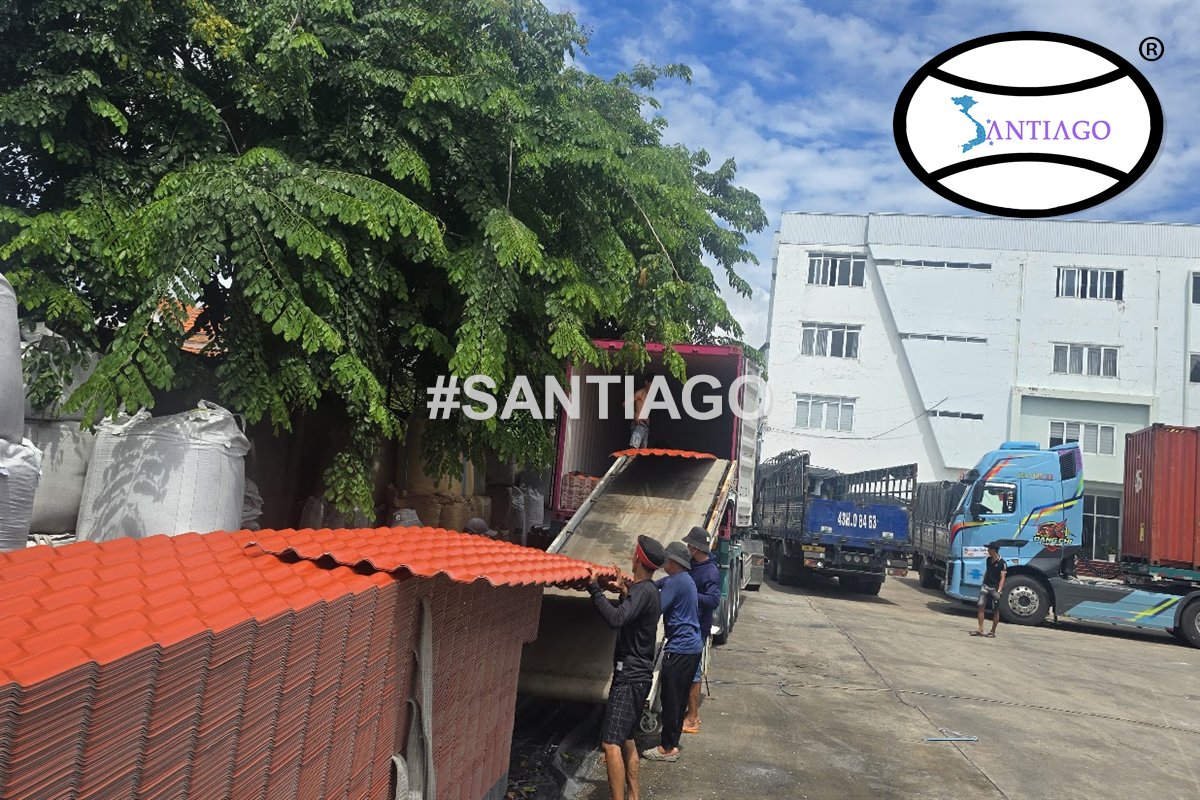 Ngói nhựa đỏ xếp cạnh xe tải chờ giao (tháng 6/2026)